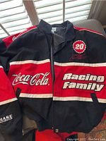 Black and red Coca-Cola NASCAR Racing Family jacket with number 20 and Tony Stewart emblems