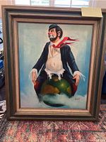 Front view of large oil painting of clown on globe in wooden frame