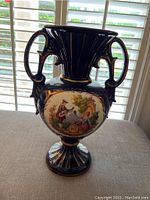 Full view of the large decorative vase showing its overall shape including two decorated handles and pedestal base.