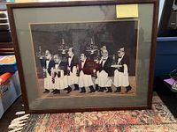 Full view of the framed black and white waiter print on the floor, showing wood frame and matting.