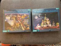 Two sealed puzzles: Las Vegas cityscape and St Basil's Cathedral at night, both 2000 pieces.