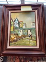 Full view of signed oil painting with original wood frame and visible architectural scenery.