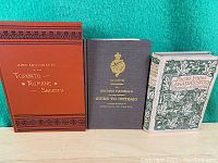 Photo of all three books standing side by side showing front covers.