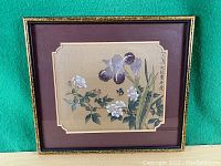 Full view of the framed Chinese silk painting showing flowers, butterfly, and calligraphy against a beige mat and green background.