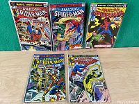 Front view of all five Amazing Spider-Man comic books laid out on a flat surface.