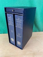 Two Oxford English Dictionary volumes inside navy slipcase with drawer.