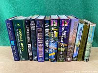 Side view of 13 vintage hardcover science fiction and fantasy books showing titles and authors.