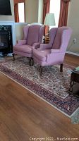 Full view of the area rug with two pink armchairs and a lamp on top, showing the overall size and pattern.