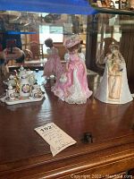 Show overall lot with Goebel Mary figurine, doll, and tea set inside a glass cabinet.
