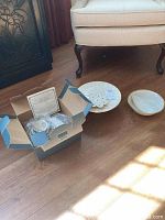 Lenox Autumn 4-piece place setting in original box with loose cake dish and bowls on floor near chair.