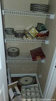 Closet shelves with stacks of Lenox Autumn plates and folded linens