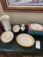 Photo of 7 Lenox porcelain items including serving bowls, vase, candy dish, ashtray, and holiday dish on black table.