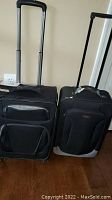 Front view of both rolling carry-on suitcases showing handles and front pockets.