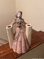 Front and side views of the vintage ceramic lady candle holder with pink floral dress and dual candle holders in each hand.