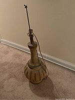 Full view of lamp base with visible lamp socket and cord, bulbous base with vertical tan stripes on greenish background.