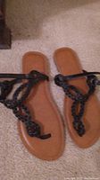 Top-down view of the women's sandals showing the braided black straps and brown soles.