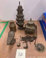 Photo shows the overall lot of incense burners and accessories arranged on a surface, highlighting different shapes and sizes of the brass items.