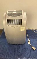 Image showing the full silver EdgeStar rolling air conditioner from front, with vent grille and power cord visible.