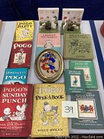Photo showing all books and art piece arranged flat with two ceramic bookends behind.