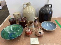 Full lot of vintage pottery items consisting of jugs, bowls, canisters, and decorative pieces arranged together showing size and glaze variations.