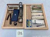 Photo of lot including vintage pens, stapler, magnifying glasses, ink bottle, and postcards.