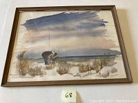 Full view of framed original watercolor painting showing a beach scene with two figures on sand dunes near the water and sky.