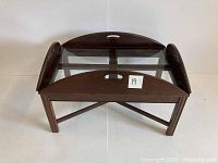Front angled view of the vintage butlers table showing wooden frame and glass top with four panels.