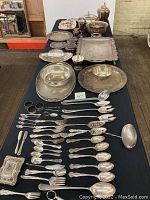 Full view of table showing trays, bowls, tea set and spread of flatware