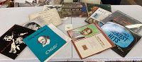 Multiple vintage LP vinyl records displayed on a white table, various genres including classical, folk, and popular music