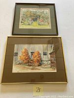 Two framed watercolor paintings. The top painting shows a garden scene while the bottom painting shows a barn with autumn trees. Both signed and in frames.