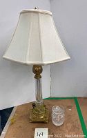 Overall view of lamp with shade and condiment jar on table surface