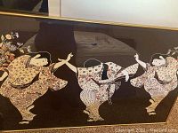 Framed art featuring three dancing ladies in floral-patterned kimonos on a dark background
