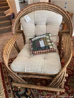 Front view of the bent branch armchair showing beige tufted cushion and patchwork pillow