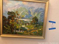 Full view of framed oil painting showing entire scenic landscape with mountains, trees, water and sky.