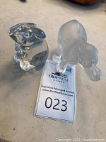 Both crystal figurines together showing size and clarity differences.