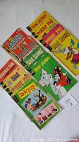 Photo showing 12 vintage comic books featuring various classic cartoon characters arranged in two rows.