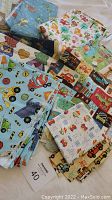 Pile of various colorful cotton and flannel fabric pieces with children's themed patterns including trucks, animals, and traffic signs.