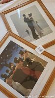 Two framed prints, one showing a dancing couple on a beach and the other showing a group under a tree at night
