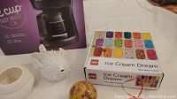 Photo showing LEGO Ice Cream Dream puzzle box, alabaster ball, white ceramic hedgehog decor, marbled ball, pink octopus ornament, and IMPERIAL coffee maker box.