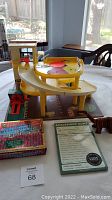 Vintage Fisher-Price yellow plastic playset with ramps, red turntable, and green mechanical lever component.