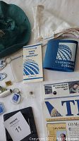 Photo including Continental Airlines hat, branded microfiber cloth, insulated drink holder, various pins and keychains, Directory booklet, and company newsletters.