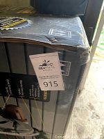 Box of new 12 inch sliding compound miter saw with laser guide, showing branding and model details.