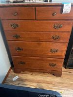Front view of Ethan Allen dresser showing five drawers with brass handles and medium brown wood finish.
