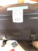 Close-up of black camera bag with 'Vanguard' brand on front, secured with two buckle clasps.