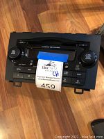 Front view of car radio with control buttons and compact disc slot.