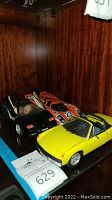 Three collectible toy cars displayed together including yellow Porsche 914, black Lamborghini Countach, and orange race car
