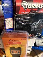 Photo showing an Actron automotive code scanner in orange box, NS disc brake pads in blue box, and Tornado alternator box.