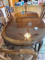 Full view of oval dining table set up with six chairs around.