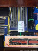 Drawer containing two blue/yellow window-box passenger cars above black Spectrum box, track underneath