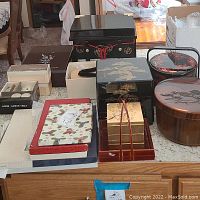 Overview of various Asian influenced items including lacquered boxes, fabrics, and wooden containers